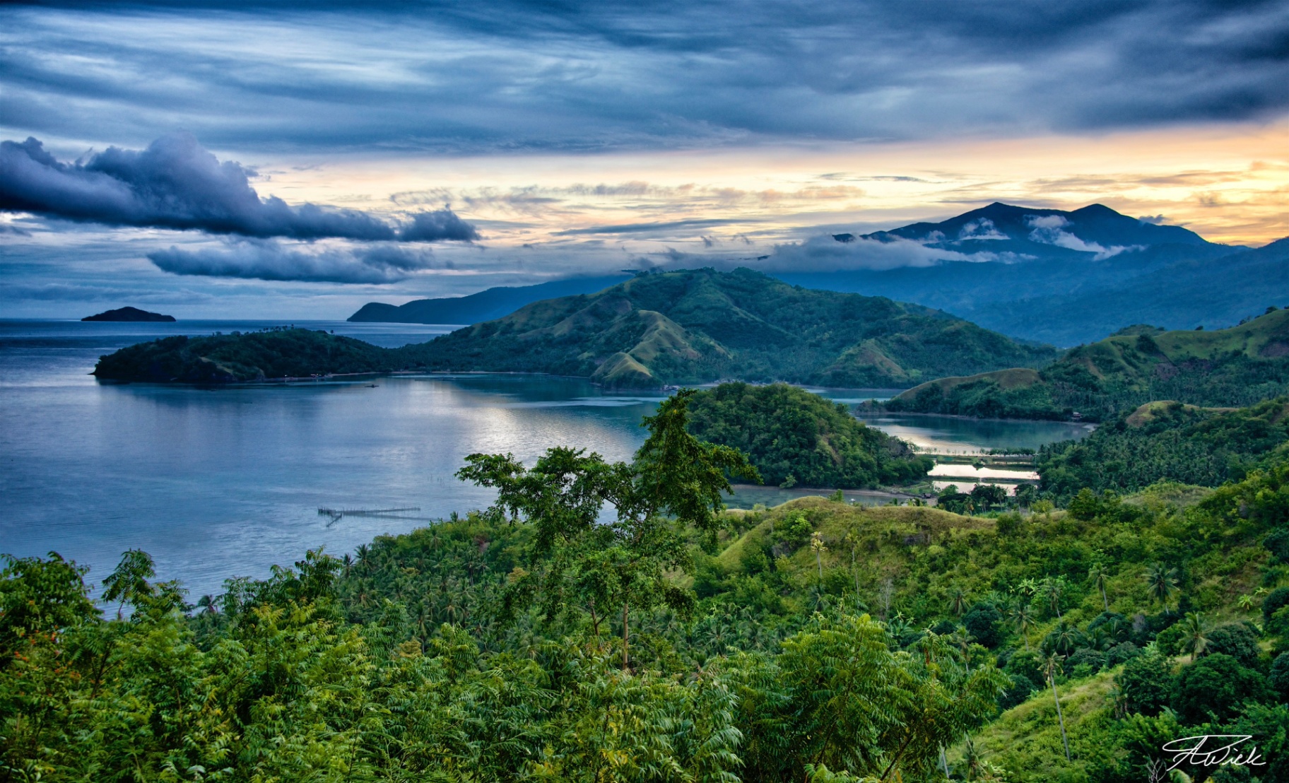 Sweeping overlook of forested islands and a quiet bay at dusk in the Philippines