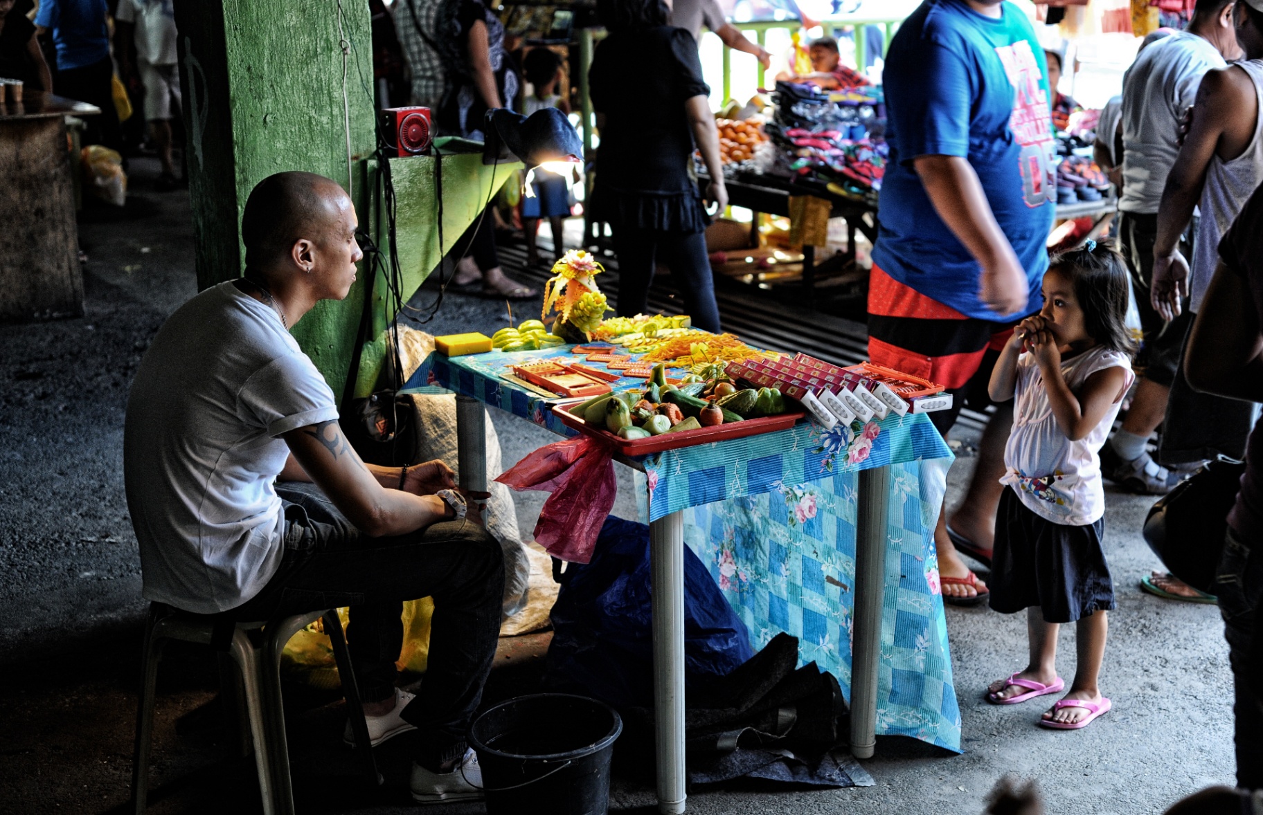Street vendor and curious child at a Philippine market